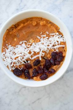 a bowl filled with oatmeal and raisins on top of a marble table