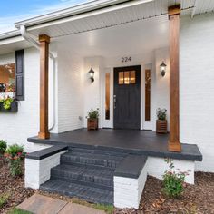 a white house with black shutters and steps leading to the front door