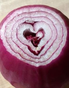 an onion is cut in half and ready to be sliced into smaller pieces with a heart shaped center