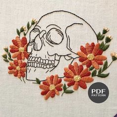 an embroidered skull with flowers on it's face is featured in the pattern book