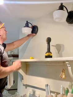 a man in an apron is pouring water into a cup on a shelf with other kitchen items