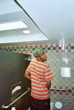 a man standing next to a urinal in a bathroom