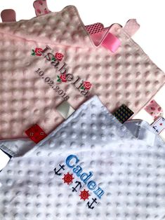 three baby bibs with name on them sitting next to each other