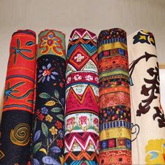 an assortment of different colored and patterned fabrics are on display with chinese characters in the background