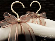 two heart shaped napkins on top of each other with ribbons and pearls attached to them