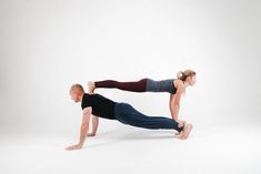 a man and woman doing push ups on their stomachs in front of a white background