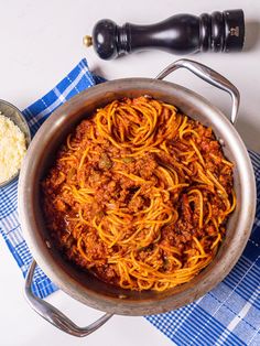 a pan filled with spaghetti next to a bowl of rice