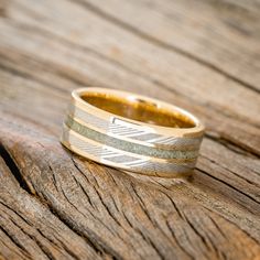 a wedding ring with two bands on top of a wooden table