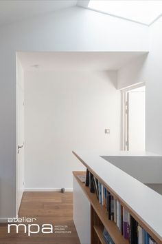 an empty room with bookshelves and a skylight