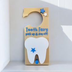 a tooth shaped door hanger with blue stars on it