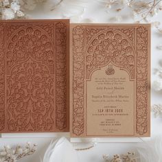 an intricate laser cut wedding card on top of flowers