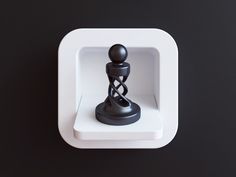 a small black figurine sitting on top of a white shelf next to a black wall