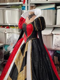 a mannequin dressed in black, red and gold with a dress on display