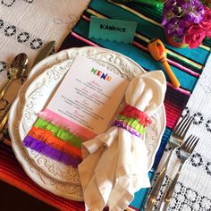 a colorful place setting with napkins and silverware