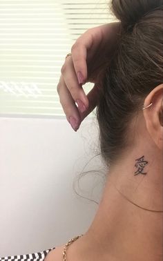 a woman with a small tattoo on her neck