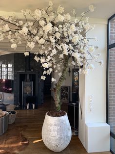 a large white vase filled with flowers on top of a wooden floor