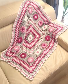 a crocheted blanket sitting on top of a couch