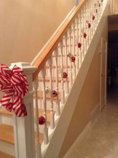 a red and white bow on the bannister of a stair case in a house