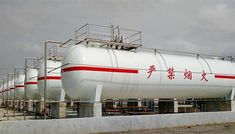 a large white tank sitting on top of a cement wall