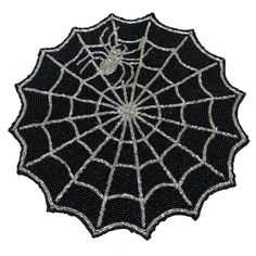 a black and white spider web with silver beads