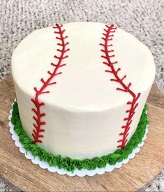 a baseball cake with green and red icing on a wooden board in the shape of a heart