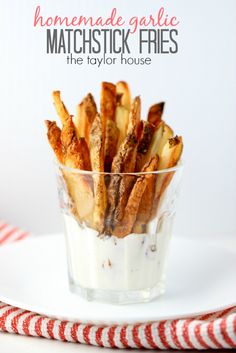 homemade garlic and matchstick fries in a small glass dish on a red and white striped napkin