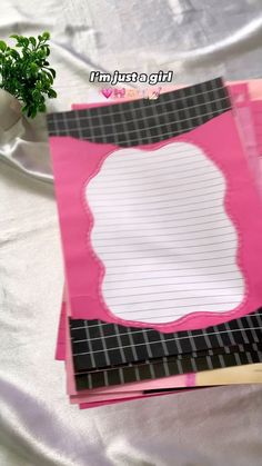 there are three pieces of paper on top of each other, one is pink and the other is black