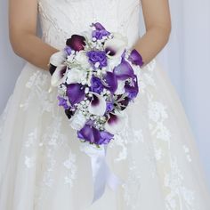 a bride holding a purple and white bouquet