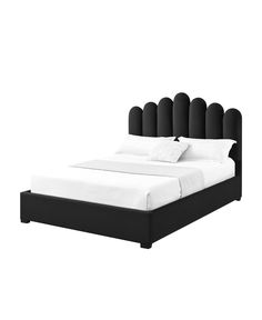 a bed with black headboard and white sheets