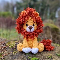 a crocheted lion sitting on top of a rock