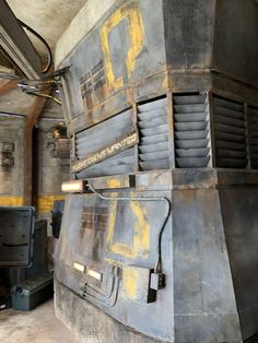 an old industrial furnace in a building that is being used as a storage area for various items