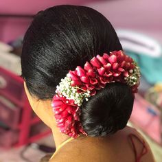 a woman with flowers in her hair is wearing a flowered bun hairstych