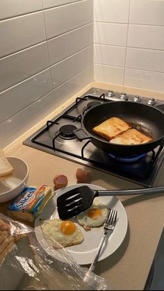 two eggs are being cooked in a frying pan on top of the gas stove