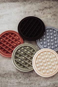 four waffle style cookies sitting next to each other on top of a cement surface