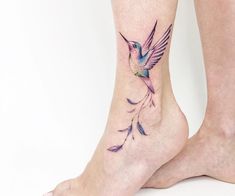 a small hummingbird tattoo on the ankle and foot, with purple flowers coming out of it