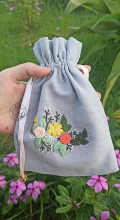 someone is holding a small bag with flowers on it