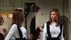 two women standing in a kitchen talking to each other and one is wearing a white shirt