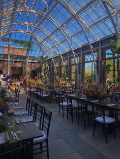 the inside of a building with tables and chairs set up for an outdoor dinner party