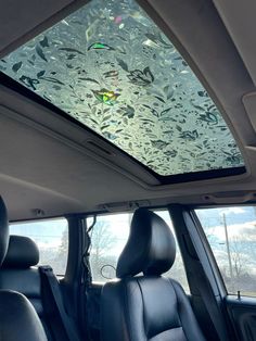 the interior of a car with glass on the roof and windows in front of it