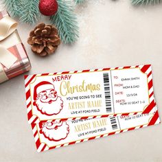 two christmas movie tickets sitting on top of a table next to pine cones and presents