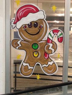 a large cut out of a ginger with a santa hat and candy cane in front of a window