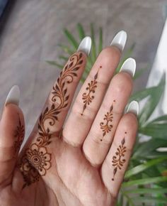 a woman's hand with hendix on it and some plants in the background