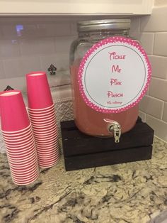 there are three pink cups on the counter next to each other and a mason jar