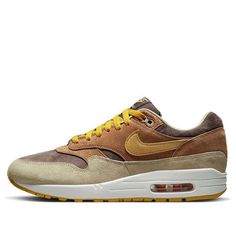 The Nike Air Max 1 Premium 'Ugly Duckling Pecan' is a stylish sneaker that is perfect for everyday wear. It features a brown leather upper with a yellow Swoosh, and a rubber sole for extra traction. The inspiration behind the design comes from the Baroque era, with the layered brown and beige leather covering the midfoot and mudguard. The yellow Swoosh and embroidered duck on the heel complete the look. This sneaker is suitable for a variety of activities, from running errands to going out with friends. (SNKR/Retro/Unisex/Low Top) Urban Brown Lace-up Custom Sneakers, Nike Casual Custom Sneakers For Outdoor, Rugged Sneakers For Streetwear, Brown Sneakers With Air Max Cushioning For Outdoor, Brown Leather Sneakers With Vibram Sole, Rugged Low-top Sneakers For Streetwear, Rugged Low-top Streetwear Sneakers, Brown Suede Sneakers For Streetwear, Brown Suede Rugged Sneakers