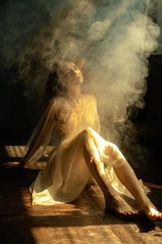 a woman is sitting on the floor with steam coming out of her face and feet