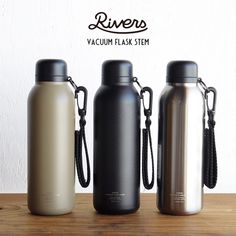 three stainless steel water bottles on a wooden table with the words rivers vacuum flask