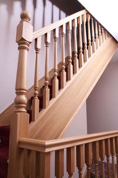 a wooden staircase with handrails and spindles