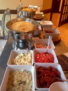 a buffet table filled with different types of food and utensils on trays