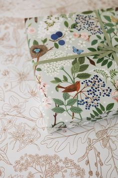 two wrappings with birds and flowers on them sitting next to each other in front of a flowery background