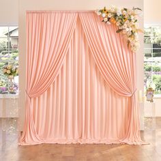 a room with pink curtains and flowers on the wall